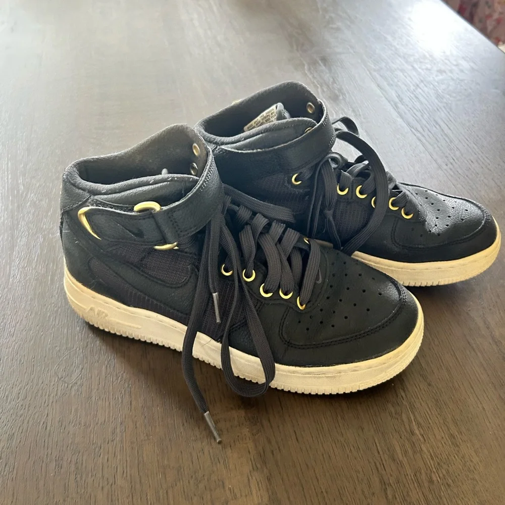 Nike Air Force ones black high top sneakers gold trim